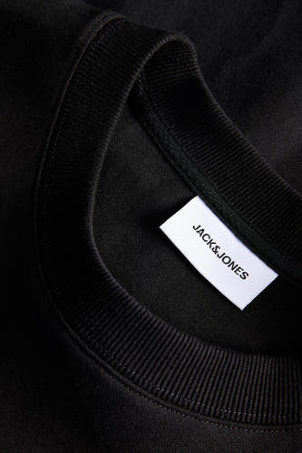 Zwarte sweater van CORE BY JACK & JONES, met geribbelde kraag en een wit label zichtbaar.
