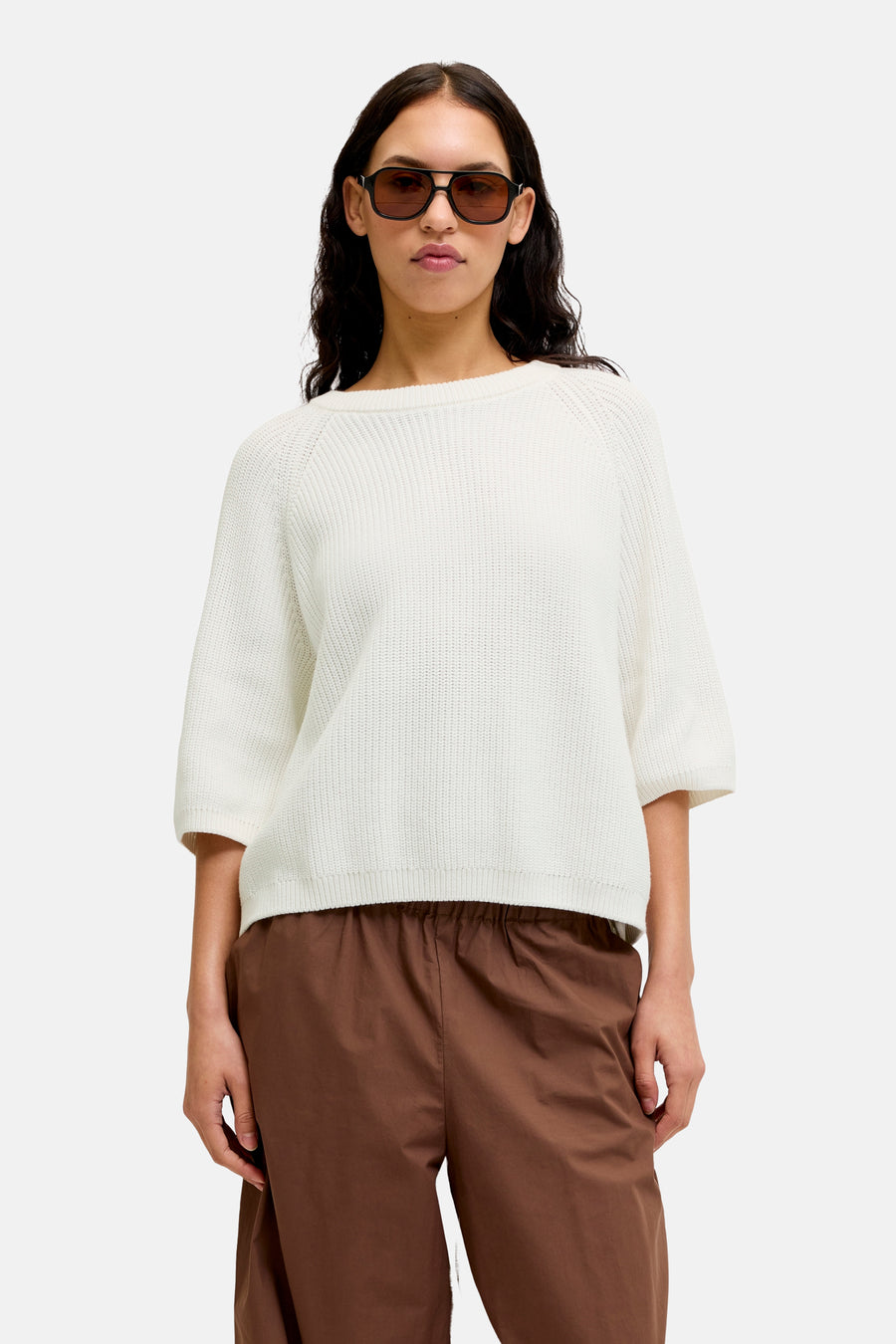Pull blanc à col rond de JJXX, à manches courtes et à texture tricotée, combiné avec un pantalon marron.