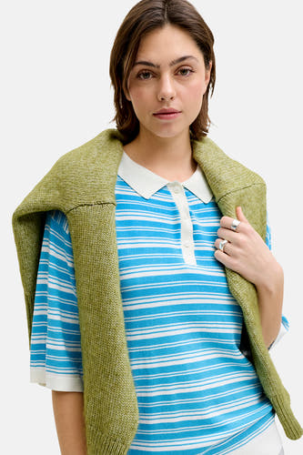 Pull bleu JJXX à rayures blanches et un pull vert lâchement sur les épaules.