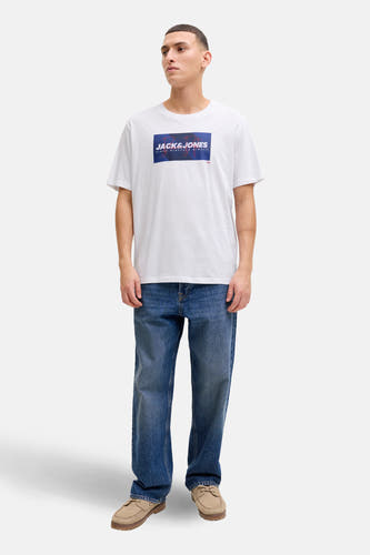 Wit T-shirt met korte mouwen van CORE by JACK & JONES, gedragen met blauwe jeans en suède schoenen.