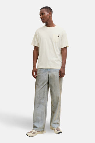 T-shirt beige à manches courtes de PREMIUM by JACK & JONES, avec une poche poitrine et porté avec un jean.