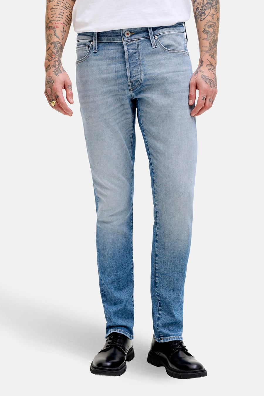 Jean slim de denim bleu clair de JACK & JONES JEANS INTELLIGENCE, associé à un T-shirt blanc et des chaussures noires.