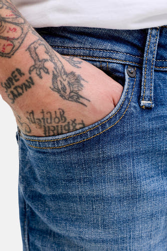Jean coupe droite bleu moyen de JACK & JONES JEANS INTELLIGENCE, avec surpiqûres jaunes et une main tatouée dans la poche avant.