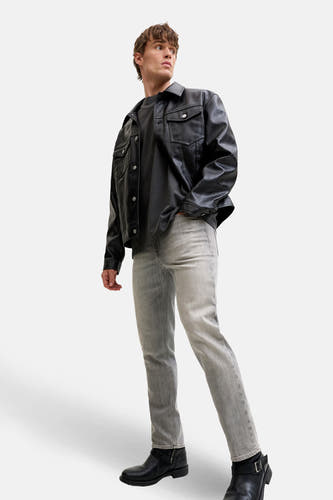 Jean droit gris denim de JACK & JONES JEANS INTELLIGENCE, associé à une veste en cuir noire et des bottes noires.
