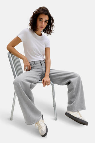 Jean gris large de JJXX, porté avec un T-shirt blanc et des baskets crème.