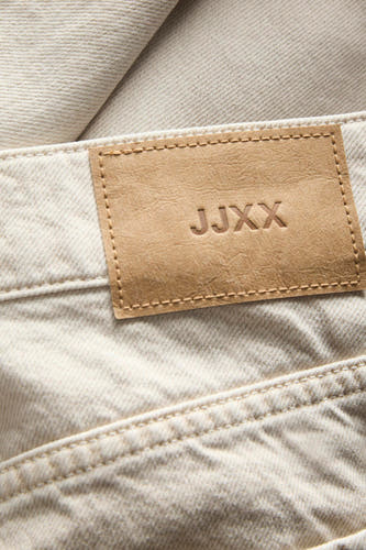 Jean écru spécial fit de JJXX, avec étiquette en cuir et détails cousus.