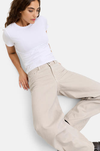Jean écru spécial fit de JJXX, avec des jambes larges et une femme portant un t-shirt blanc.