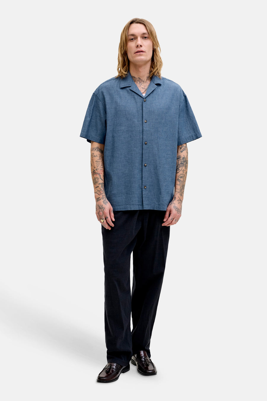 Blauw overhemd met korte mouwen van PREMIUM by JACK & JONES, met knoopsluiting en gedragen met zwarte pantalon en bruine loafers.