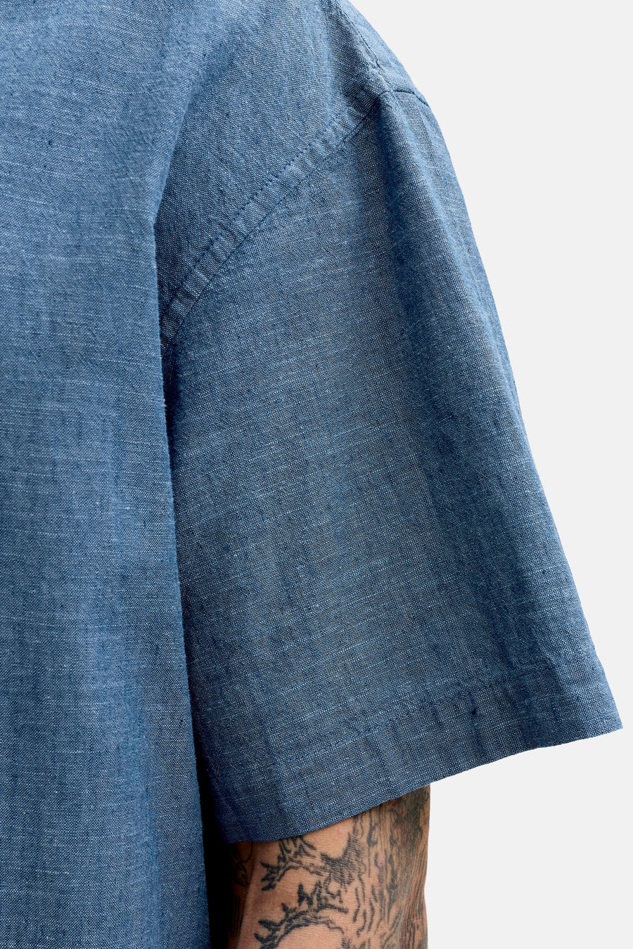 Chemise bleue à manches courtes de PREMIUM by JACK & JONES, avec un tissu texturé et un tatouage visible sur le bras.