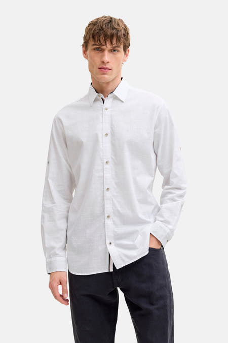 Chemise blanche à manches longues de PREMIUM by JACK & JONES, portée avec une veste beige, un pantalon noir et des chaussures marron.