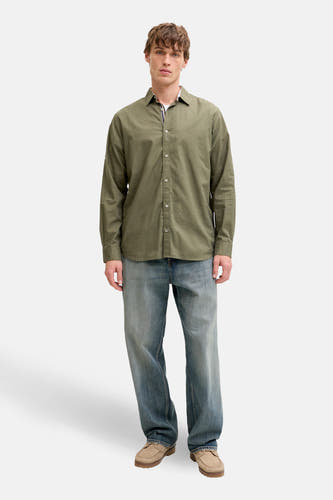 Groen hemd met lange mouwen van PREMIUM by JACK & JONES, gedragen met blauwe jeans en suède schoenen.