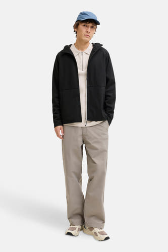 Gilet noir de CORE BY JACK & JONES, porté sur une chemise beige à fermeture éclair et un chapeau bleu.