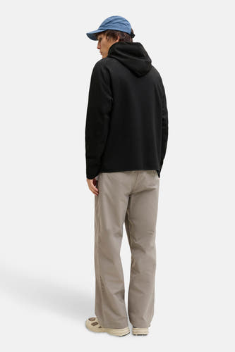 Gilet noir de CORE BY JACK & JONES, vu de derrière, associé à un chapeau bleu et une pantalon kaki.