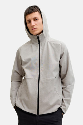 Gilet gris de CORE BY JACK & JONES, avec des fermetures éclair noires et un capuchon, porté sur une pantalon noir.