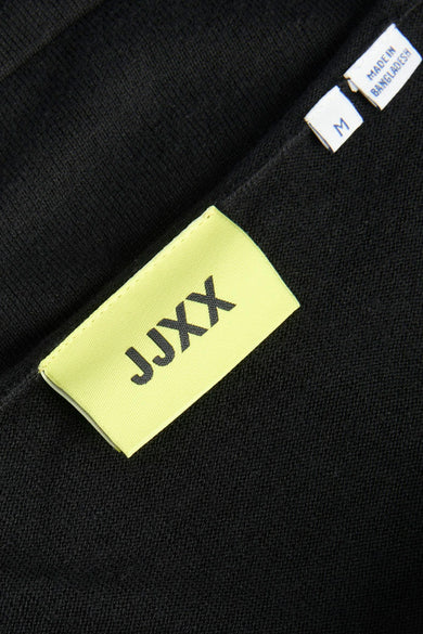 Pull noir de JJXX, avec une étiquette jaune et une étiquette indiquant la taille et le pays d'origine.
