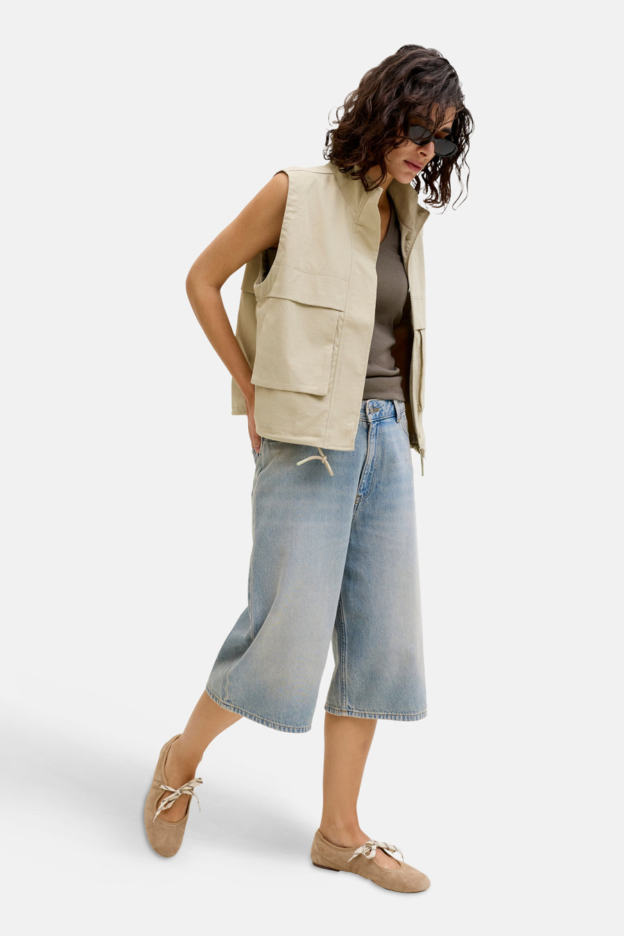Lichtblauwe denim short van JJXX, gecombineerd met een kaki vest en bruine ballerina's.