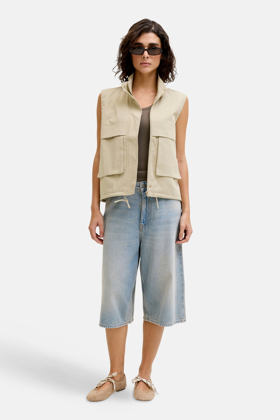 Korte lichtblauwe denim short van JJXX, gecombineerd met een mouwloos vest en ballerina's met strik.
