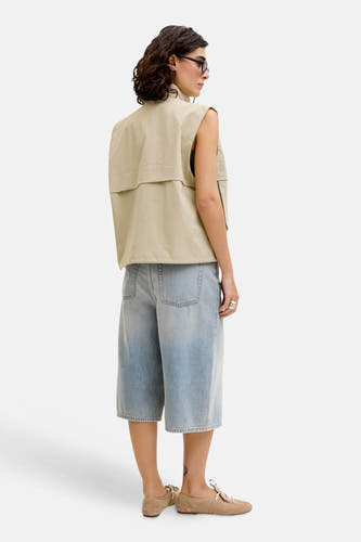 Short en jean bleu clair de JJXX, avec jambes larges et porté avec un cardigan beige et des chaussures plates.
