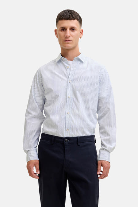 Chemise blanche à manches longues de PREMIUM by JACK & JONES, avec un dessin subtil et portée avec un pantalon foncé.
