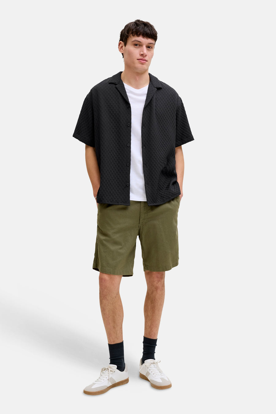 Chemise noire à manches courtes de CORE BY JACK & JONES, avec un relief subtil et portée sur un t-shirt blanc.