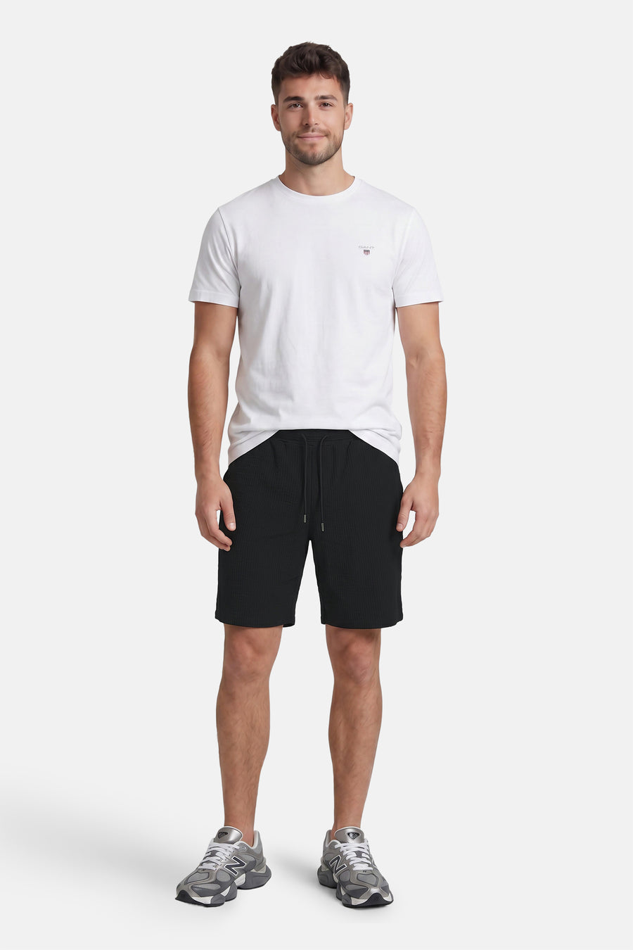 Zwarte katoenen shorts met ruitjesstructuur van JACK & JONES JEANS INTELLIGENCE, voorzien van trekkoord, gedragen met wit T-shirt en grijze sneakers, front view.