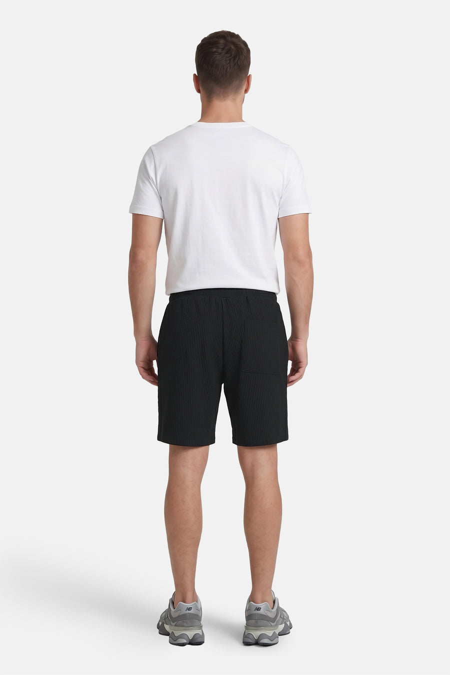 Zwarte ribbelshort van JACK & JONES JEANS INTELLIGENCE, achterkant met zak, model draagt wit T-shirt en grijze sneakers