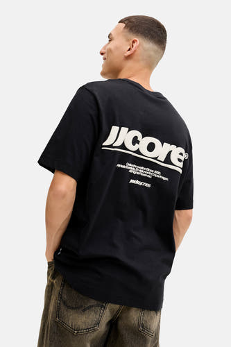 T-shirt noir à manches courtes de CORE par JACK & JONES, avec du texte blanc sur l'arrière et un pantalon foncé.