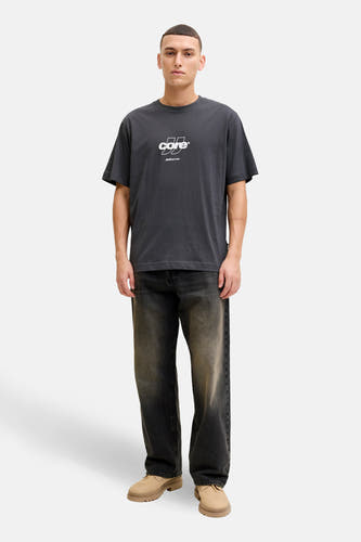 T-shirt gris à manches courtes de CORE BY JACK & JONES, porté avec un jean foncé et des chaussures beiges.