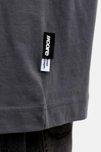 T-shirt gris à manches courtes de CORE BY JACK & JONES, avec une étiquette de marque sur le côté et un design uni.