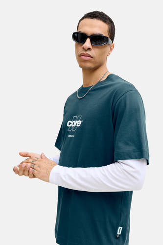 T-shirt bleu à manches courtes de CORE BY JACK & JONES, avec logo blanc sur la poitrine et une chaîne argentée.