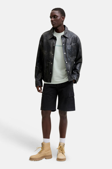 Groene korte mouwen t-shirt van CORE BY JACK & JONES, met subtiele streep op borst, gedragen onder zwarte leren jas en korte broek, lifestyle shot.