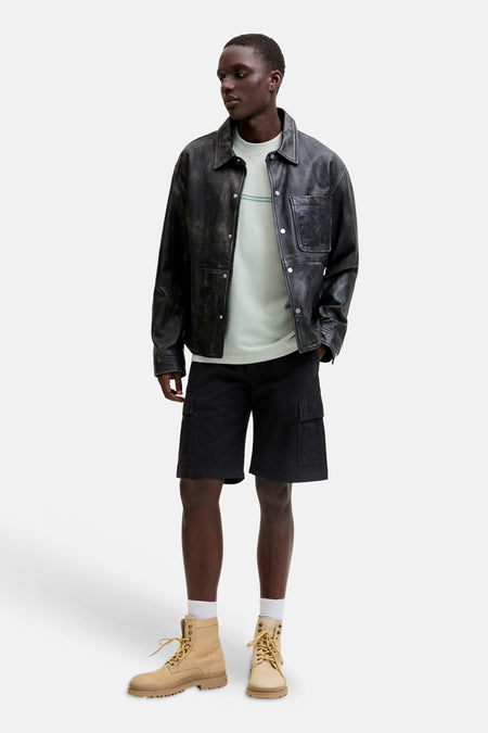 Groene korte mouwen t-shirt van CORE BY JACK & JONES, met subtiele streep op borst, gedragen onder zwarte leren jas en korte broek, lifestyle shot.