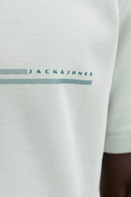 Groene korte mouw t-shirt van CORE BY JACK & JONES met subtiel logo en gestippelde strepen, close-up op borst.