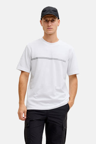 T-shirt blanc à manches courtes de CORE BY JACK & JONES, porté sous une veste beige avec un pantalon cargo noir et des baskets grises.