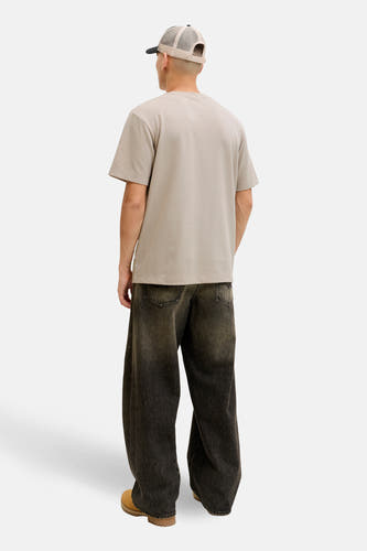 T-shirt beige à manches courtes CORE BY JACK & JONES, coupe décontractée, porté avec une casquette et un jean ample.