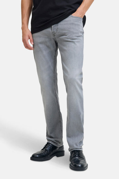 Jean slim bleu clair de JACK & JONES JEANS INTELLIGENCE, avec un haut noir et des chaussures noires.