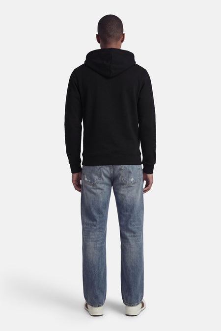 Sweat à capuche noir de CORE BY JACK & JONES, vu de dos, avec un jean et des baskets blanches.
