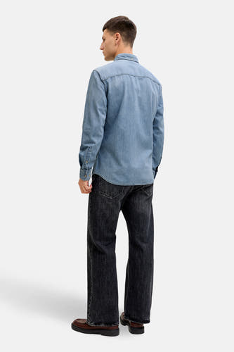 T-shirt en jeans de denim bleu clair d'ORIGINALS BY JACK & JONES, avec des manches longues, porté avec des jeans gris foncé et des chaussures marron.