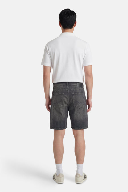 Grijze denim jeansshort van JACK & JONES JEANS INTELLIGENCE, met achterzakken en een witte polo en sneakers.