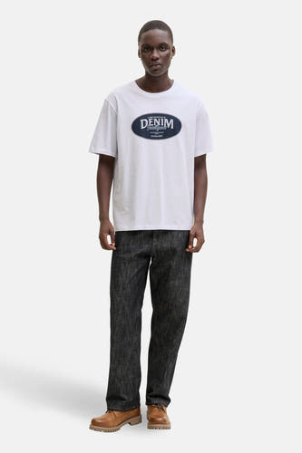 Wit T-shirt met korte mouwen van ORIGINALS by JACK & JONES, met opdruk op de borst, gecombineerd met een donkere jeans en bruine schoenen.