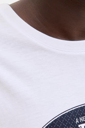 T-shirt blanc à manches courtes d'ORIGINALS BY JACK & JONES, gros plan sur la ligne du col et une partie d'un motif bleu.