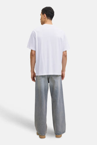 T-shirt blanc à manches courtes d'ORIGINALS BY JACK & JONES, vu de l'arrière, associé à des jeans larges et des chaussures marrons.