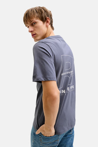T-shirt bleu à manches courtes de JJREBEL, avec imprimé blanc au dos et porté avec un jean.