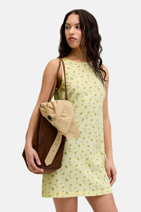 Robe sans manches jaune de JJXX avec motif à carreaux subtil et petits imprimés citron jaune, porté avec des bottes foncées et un sac marron.