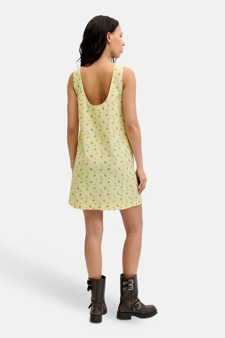Robe jaune sans manches de JJXX à carreaux vichy et imprimé fleuri, vue de dos, portée avec des bottes foncées.