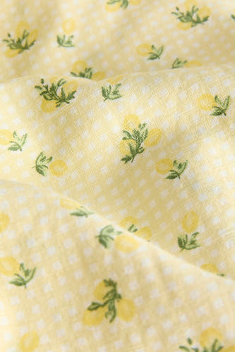 Robe jaune JJXX à motif à carreaux et imprimé citron, gros plan du tissu plié.