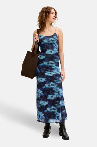 Blauw kleedje zonder mouwen van JJXX, met een bloemenpatroon en gecombineerd met laarzen en een bruine tas.