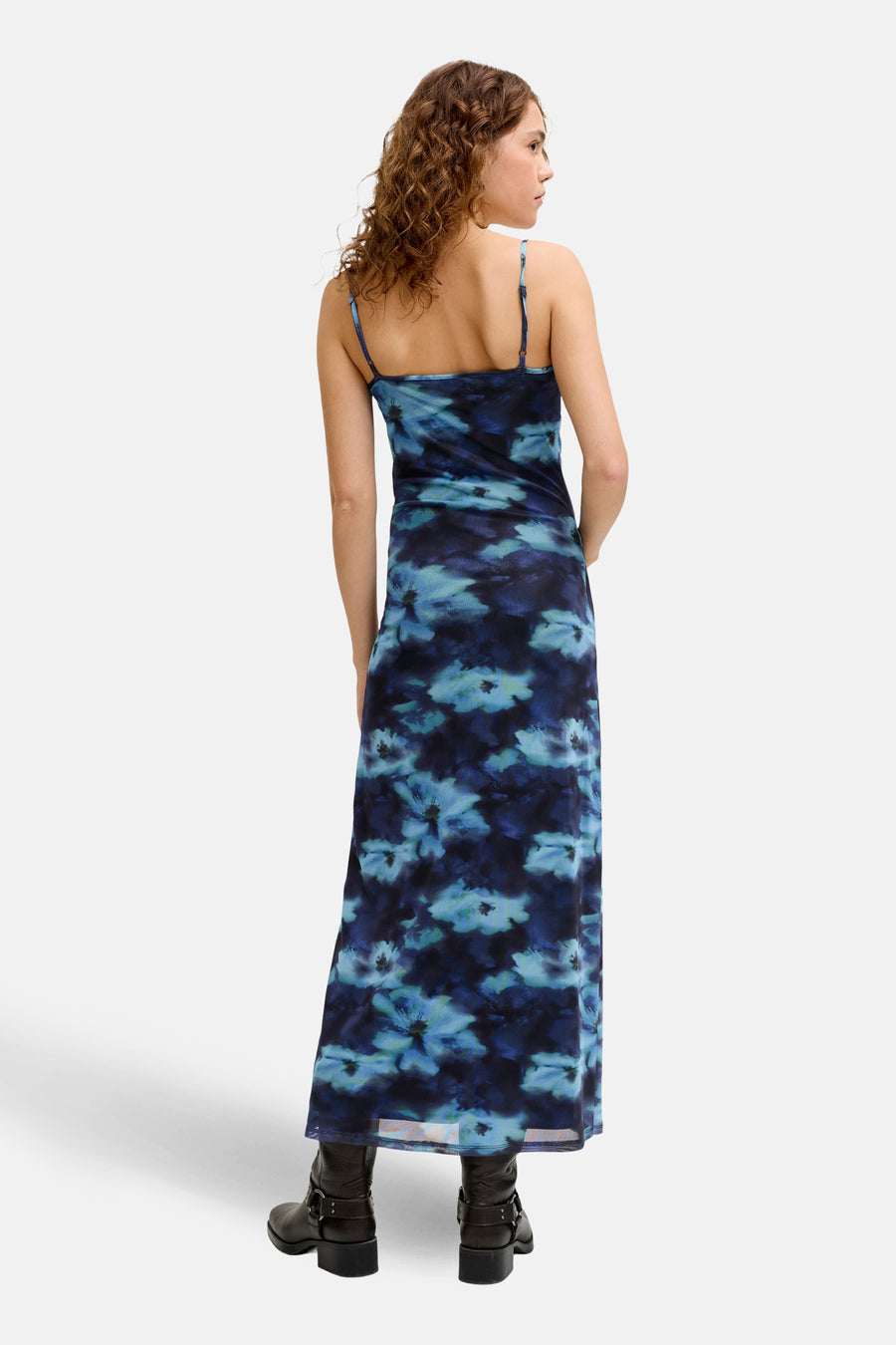 Robe bleue sans manches de JJXX, avec un motif floral et associée à des bottes noires.