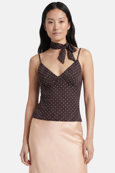 Bruine blouse van JJXX met witte stippen, spaghettibandjes en V-hals, gedragen met bijpassende halsdoek en roze rok.