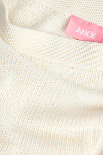 Jupe blanche JJXX à motif ajouré, bord côtelé et étiquette rose, en gros plan.